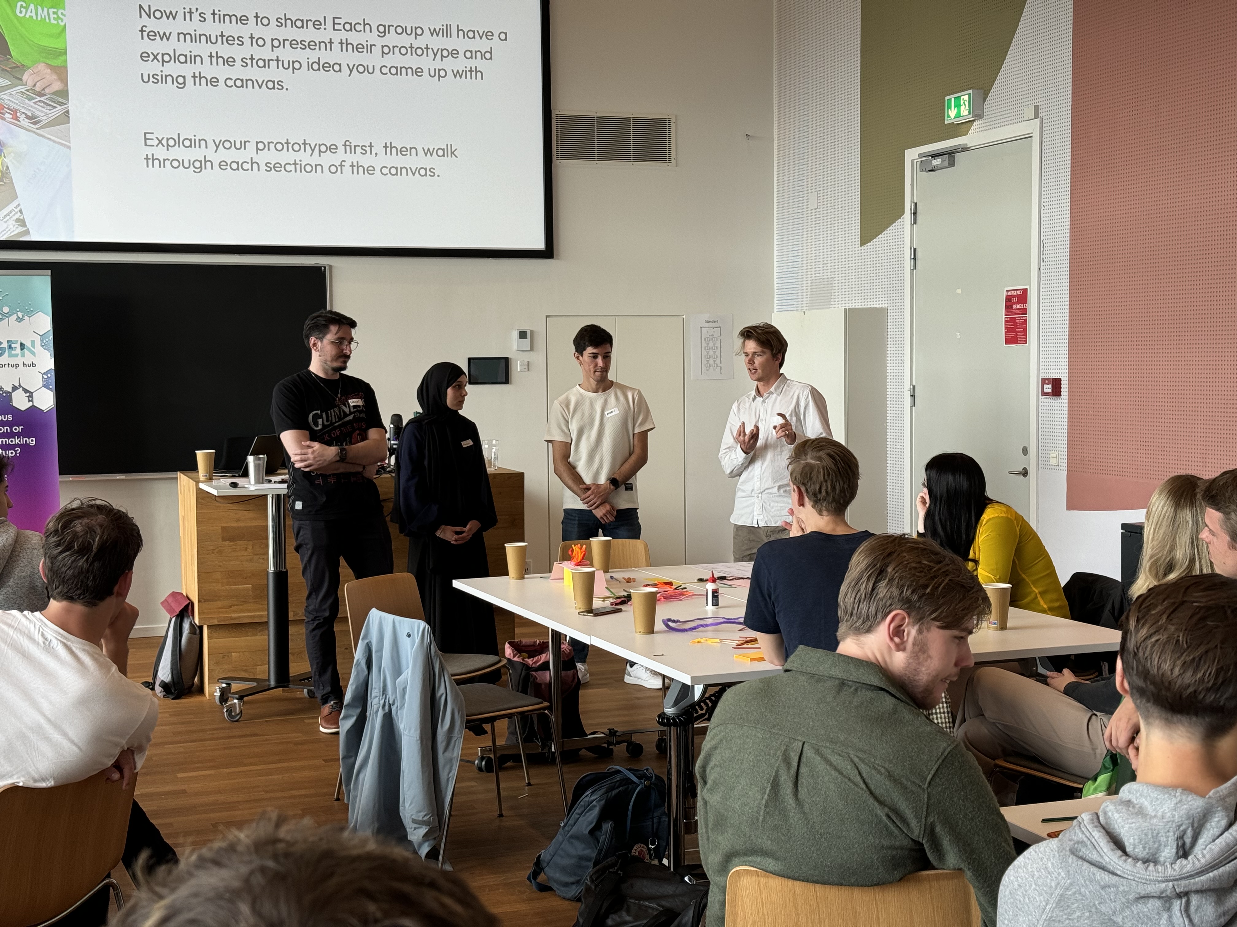 Four people presenting a project to a classroom